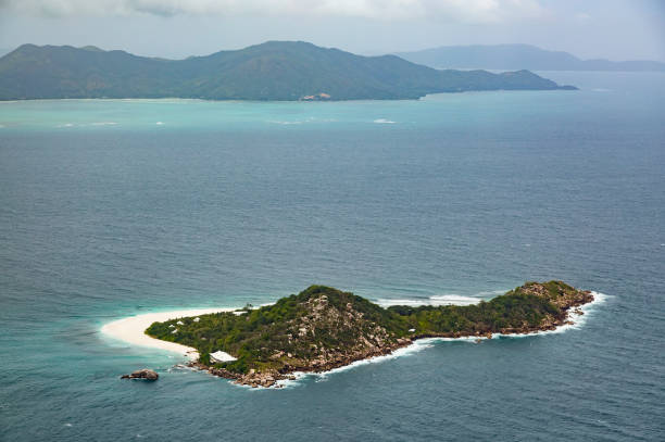 Heart-shaped tropical island in middle of the ocean and a boat going through. This is a 3d render illustration