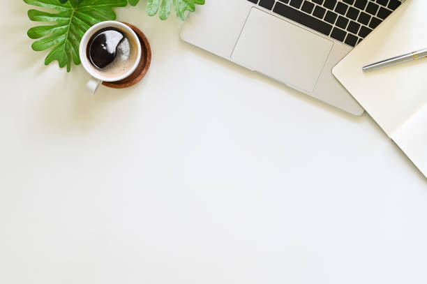 istock Office desk with laptop computer, notebook and coffee on white table top view. 1149719035