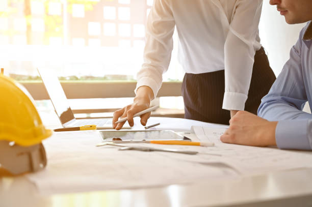 istock Architect planning blueprint in digital tablet with construction meeting and planning concept. 1149719425