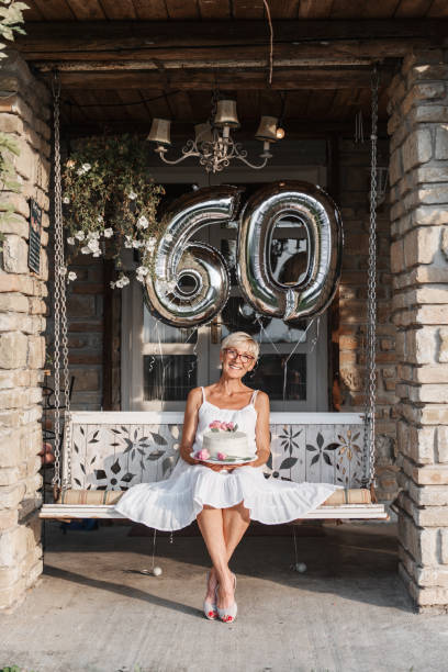 Senior woman celebrating her 60th birthday, with balloons