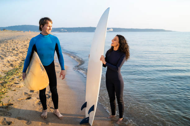 istock Surfers holding surfboards on beach 1149725068