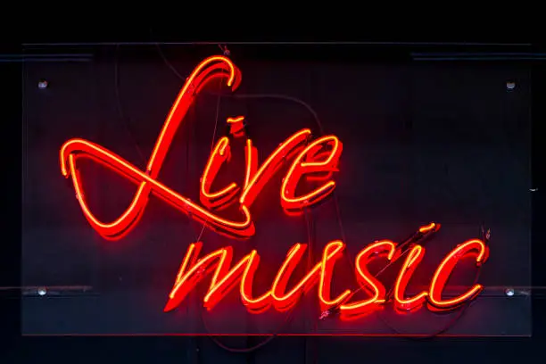Close-up on a red neon light shaped into the short phrase "Live Music".