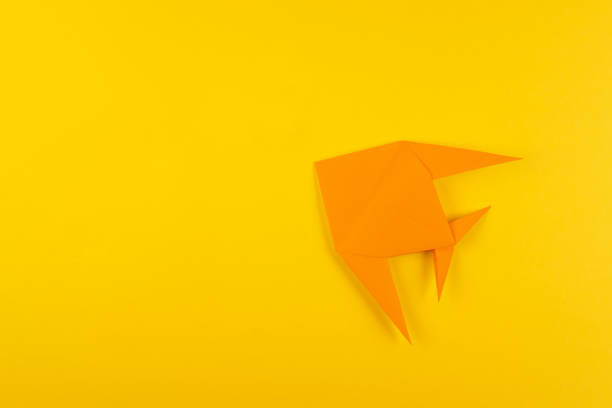 istock Origami tropical fish on yellow minimalistic background 1149726992