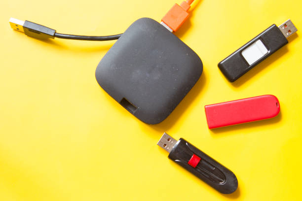 istock Black USB HUB with usb stick flash drives on yellow background. Top view. 1149728892