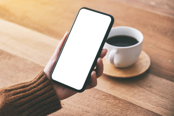 istock woman's hand holding black mobile phone with blank screen 1149731272
