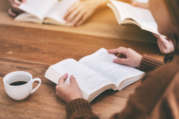 personas sentadas y disfrutaban leyendo libros juntos - intend fotografías e imágenes de stock