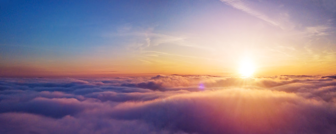 Beautiful sunset cloudy sky from aerial view. Airplane view above clouds