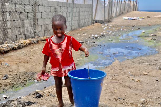 istock Smiling Girl Holding Bucket While Walking On Field 1149737055