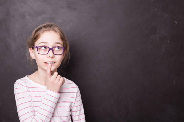 istock School - child girl (kid, pupil) thinking at the blackboard 1149739371