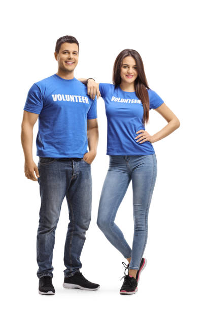 Young man and woman volunteers in blue t-shirts posing Full length portrait of young man and woman volunteers in blue t-shirts posing isolated on white background contributor stock pictures, royalty-free photos & images
