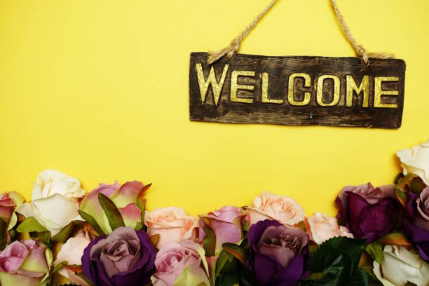 istock welcome sign with rose flower on yellow background 1149746169
