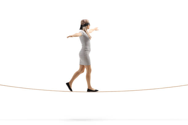 Woman walking on a rope and wearing blindfold