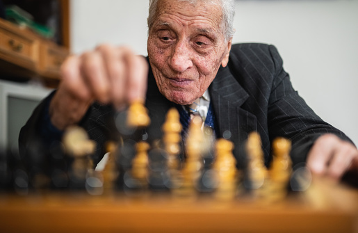 Elderly man playing chess.