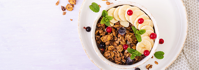 Breakfast. Bowl of homemade granola with yogurt and fresh berries. Table setting. Healthy food. Banner. Top view.