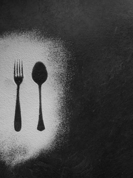 istock Spoon and fork silhouette made with flour on dark texture background, up vertical view 1149750780