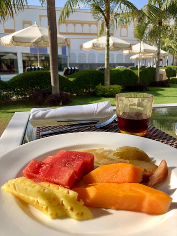 Stock photo showing a healthy eating breakfast fruit platter with plates of juicy, ripe sliced diced melon, papaya and fresh pineapple. Fruit salad breakfast buffet, with healthy fruit and vegetables.