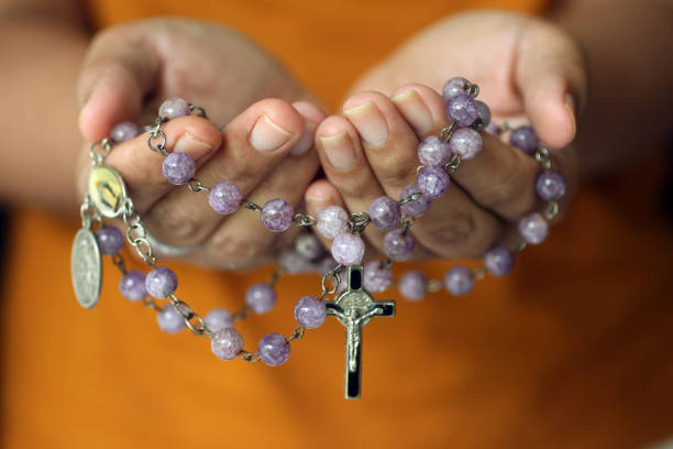 Purple Rosary in Hand. Prayer lady stock photo