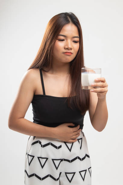 femme asiatique buvant un verre de lait a eu la douleur stomachache. - got milk photos et images de collection