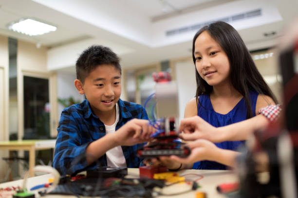 istock Group of young science students assembling electrical components on their robot in the classroom. 1149754029