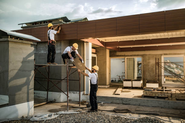 Team of construction workers cooperating while working on a house exterior.