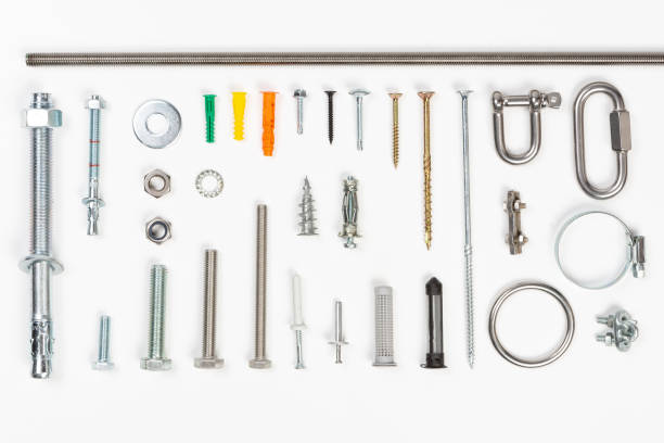 Top view of assorted materials carpenters use  like screws, bolts, fixings, nuts screws and nails on a white background.