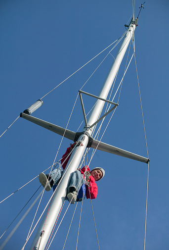 female skipper, checking the rigg of her sailing yacht