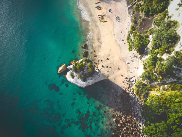 Kayakers walk along the sand
