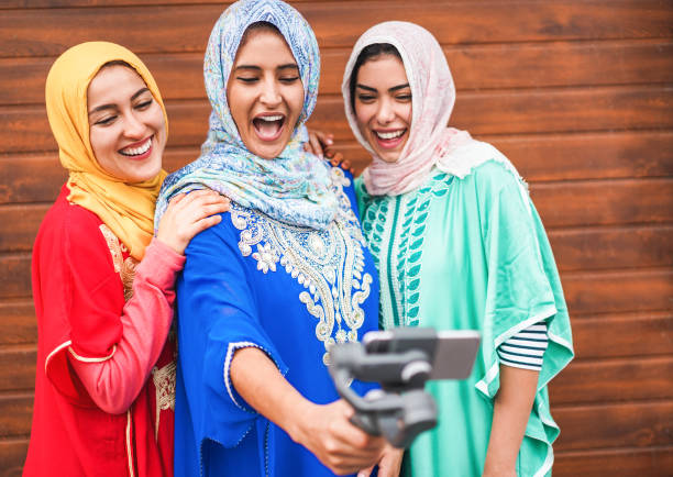 Happy arabian friends using smartphone for making video vlog on social network - Young girls with hijab having fun with new trend technology - Friendship concept - Focus on left women faces Happy arabian friends using smartphone for making video vlog on social network - Young girls with hijab having fun with new trend technology - Friendship concept - Focus on left women faces moroccan girl stock pictures, royalty-free photos & images