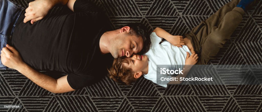 Father and Son Cuddle on the floor Son Stock Photo