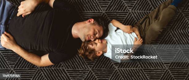 Father And Son Cuddle On The Floor Stock Photo - Download Image Now - Son, Father, Child