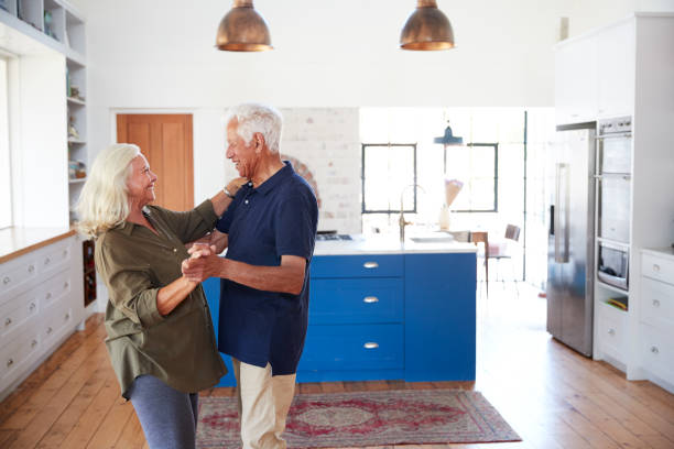 istock Senior Couple At Home Dancing In Kitchen Together 1149759217