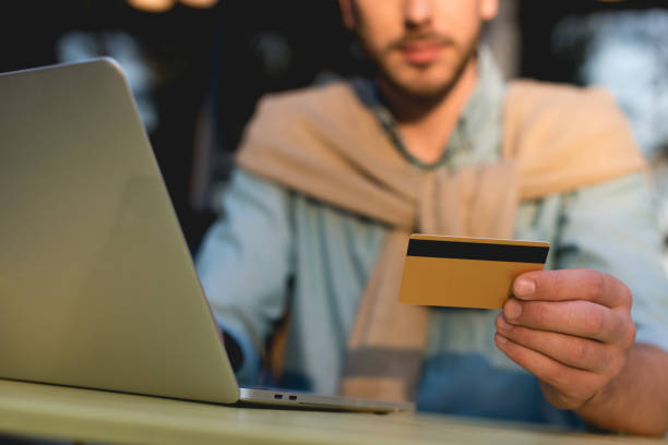 istock cropped view of man holding credit card while using laptop 1149759871