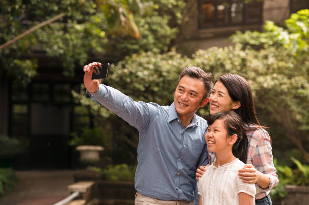 istock Small family taking selfies together in the park 1149760709