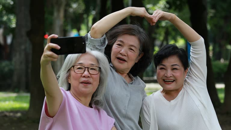 Three Elderly Taiwanese Ladies Having Fun Taking Selfies At Park