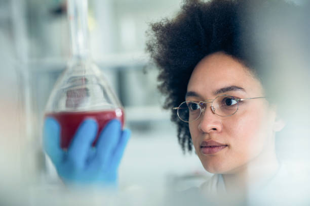 istock Young African American scientist examining liquid in a beaker. 1149764618