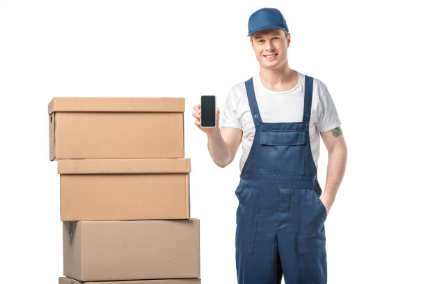istock smiling mover with cardboard boxes presenting smartphone with blank screen isolated on white 1149766549