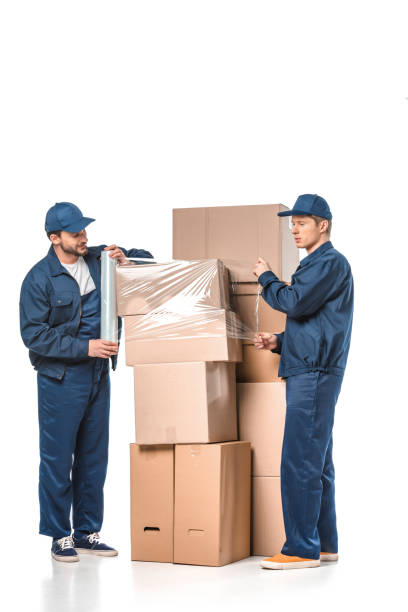 istock two movers wrapping cardboard boxes with roll of stretch film on white 1149766640