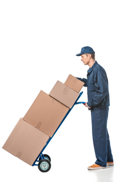 istock mover in uniform transporting cardboard boxes on hand truck isolated on white with copy space 1149766648