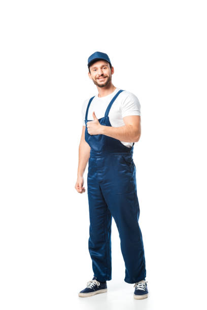 istock handsome smiling mover in uniform looking at camera and showing thumb up sign isolated on white 1149768940