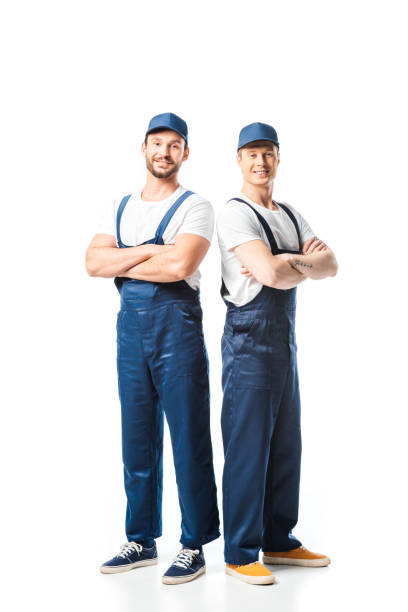 istock two smiling movers in uniform with arms crossed looking at camera on white 1149768963