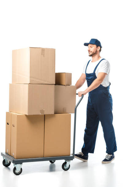 istock handsome mover in uniform transporting cardboard boxes on hand truck isolated on white 1149768971