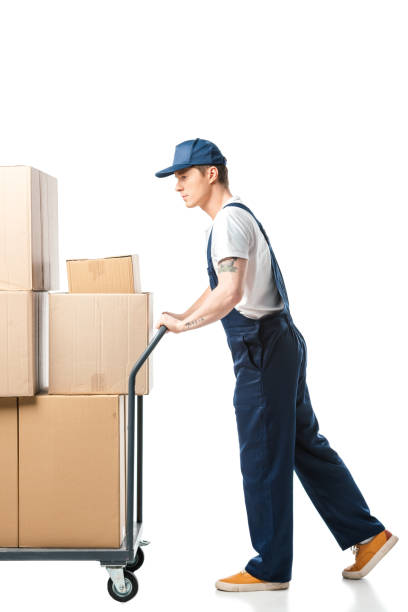 istock mover in uniform transporting cardboard boxes on hand truck isolated on white 1149768978
