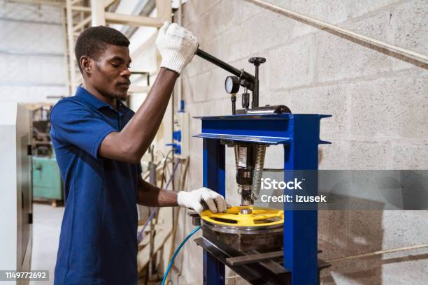 Male Engineer Working On Wheel With Lathe Machine Stock Photo - Download Image Now - Engineer, 25-29 Years, Adjusting