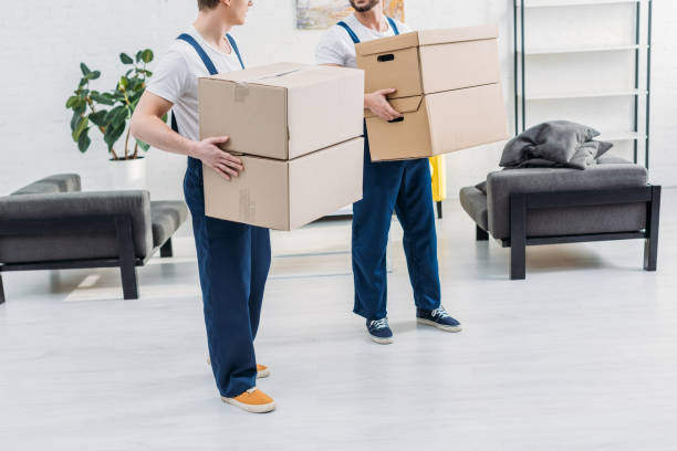 istock cropped view of two movers in uniform carrying cardboard boxes in apartment 1149772755