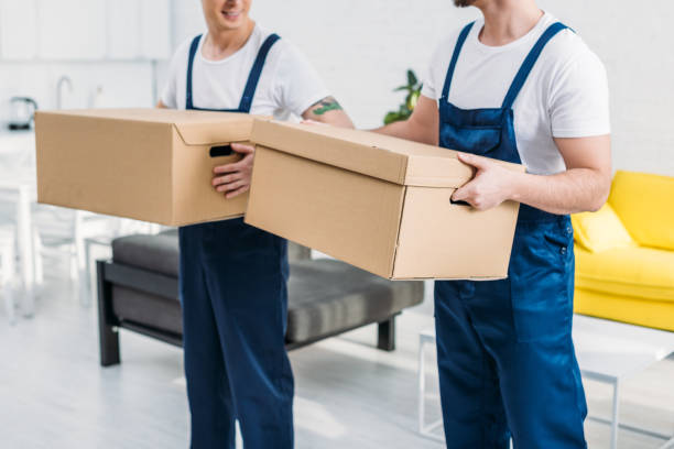 istock cropped view of two movers transporting cardboard boxes in apartment 1149772792