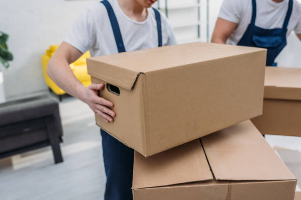 istock cropped view of two movers transporting cardboard boxes in apartment 1149772809