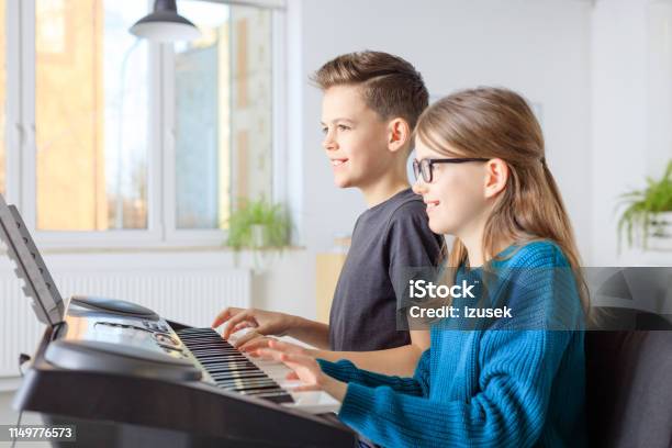 Preadolescent Friends Playing Piano In Class Stock Photo - Download Image Now - Piano, Boys, Child