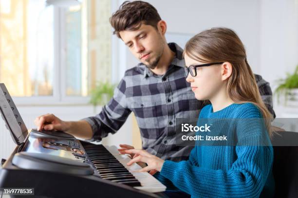 Teacher With Student Playing Piano In Class Stock Photo - Download Image Now - Piano, 10-11 Years, Instructor