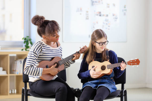 istock Trainer teaching girl plucking ukulele in class 1149780167