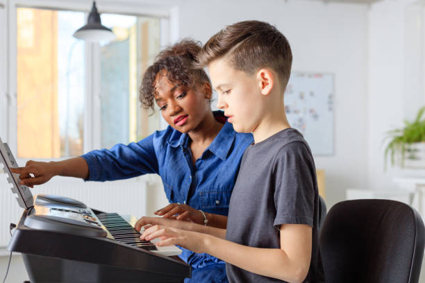 istock Trainer showing sheet to student and playing piano 1149780540